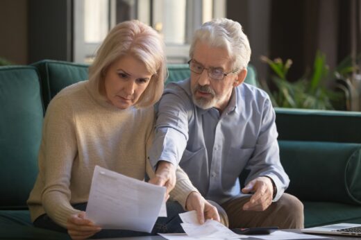 Serious,grey,haired,mature,couple,calculating,bills,,checking,finances,together