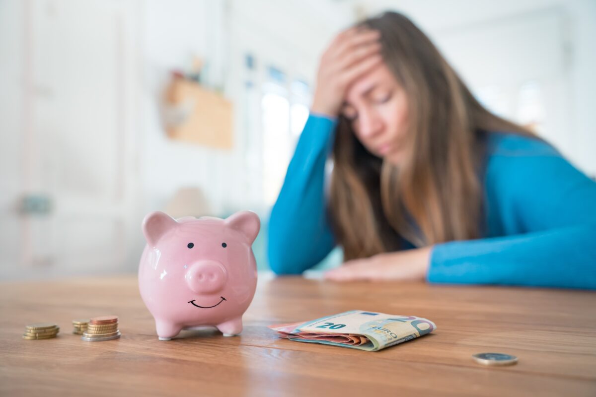 Woman,with,pink,piggy,bank,is,worried,about,money,and