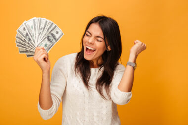 Portrait,of,a,cheerful,young,woman,holding,money,banknotes,and