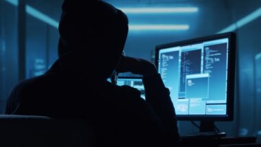 Computer,hacker,in,hoodie.,obscured,dark,face.,concept,of,hacker