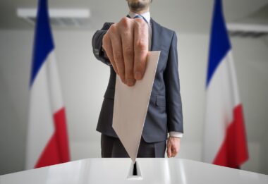 Election,in,france.,voter,holds,envelope,in,hand,above,vote