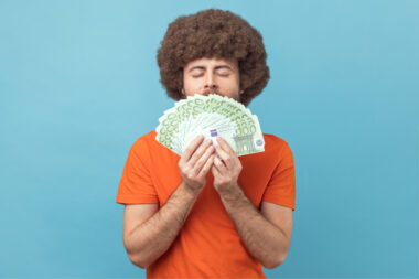 Portrait,of,greedy,man,with,afro,hairstyle,in,orange,t Shirt