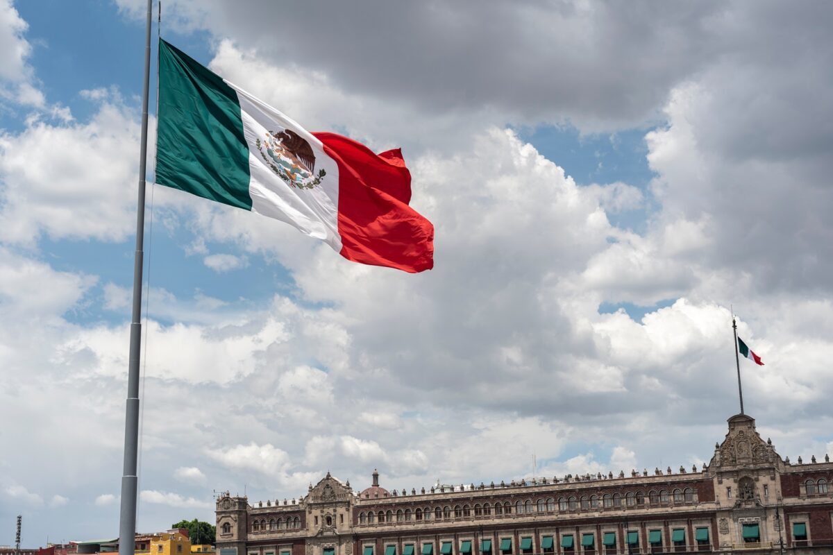 Mexican,flag,waving,with,blue,sky,and,clouds,and,the