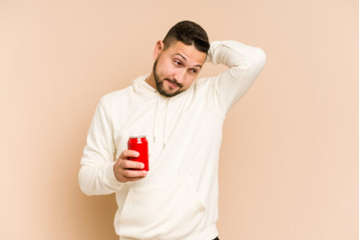 Young,latin,man,holding,a,cola,refreshment,isolated,touching,back