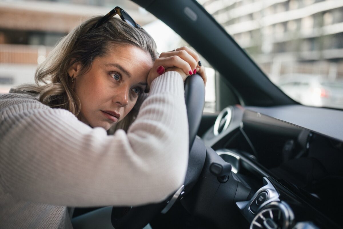 Upset,woman,driving,her,car,in,a,city.