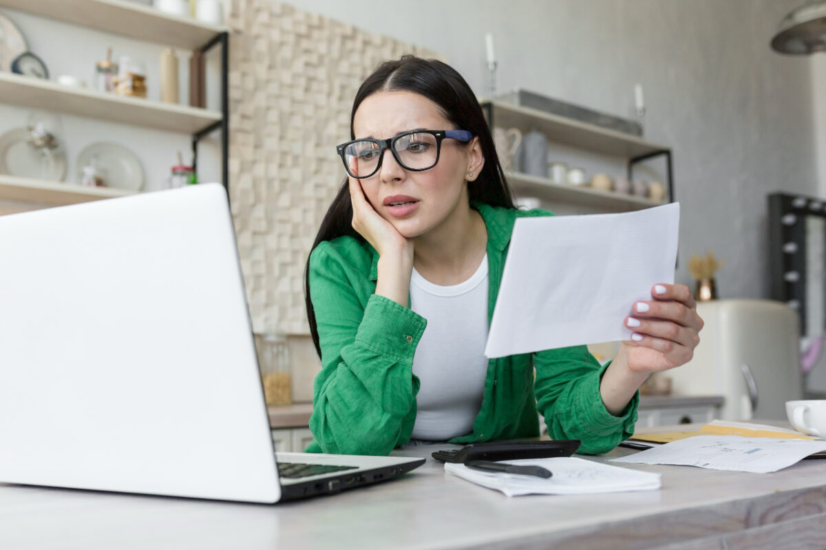 Cash,loan.,upset,and,shocked,woman,holding,bank,bill,about