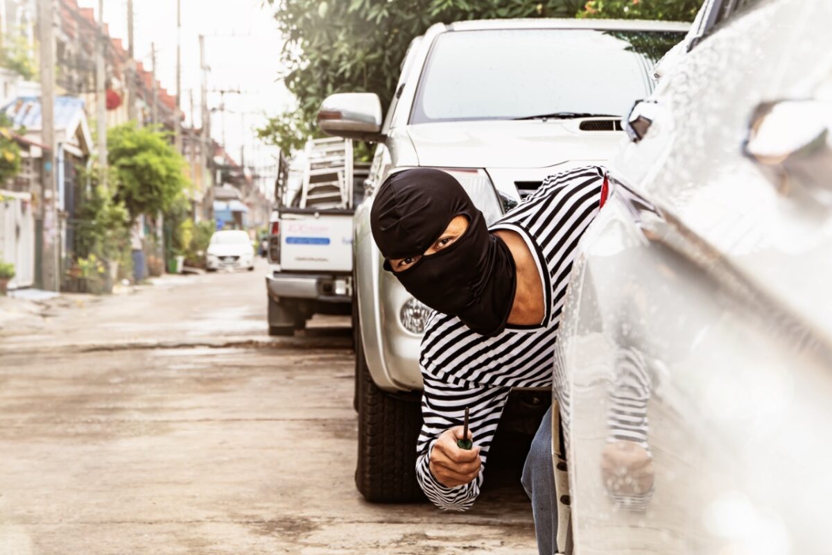 Burglar,wearing,a,robber,with,a,screwdriver,is,hiding,behind