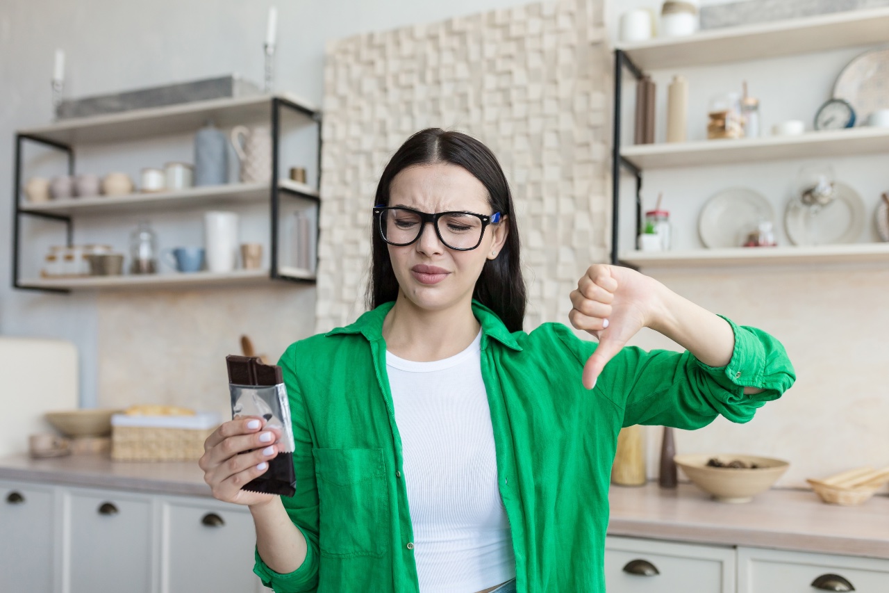 Dissatisfied,young,woman,at,home,in,the,kitchen,holding,a