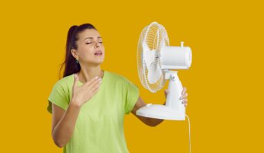 Young,woman,with,a,fan,in,her,hand,is,exhausted