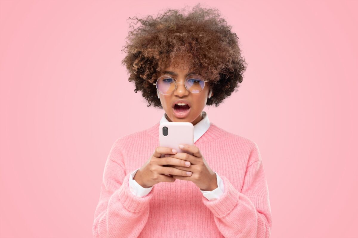 Portrait,of,african,girl,cringe,and,looking,at,phone,screen