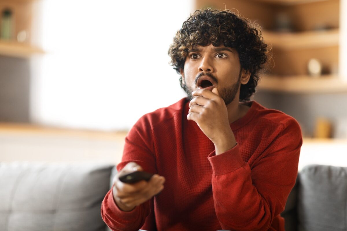 Portrait,of,shocked,indian,man,with,remote,controller,in,hand