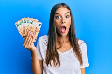 Young,hispanic,woman,holding,50,euro,banknotes,scared,and,amazed