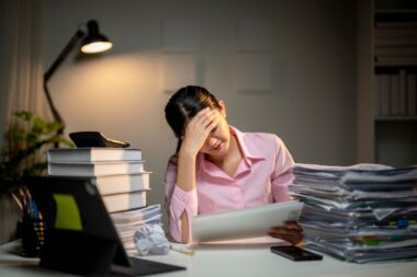 A,woman,is,sitting,at,a,desk,with,a,laptop